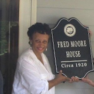 Fred Moore House plaque, circa 1920, held by a visitor